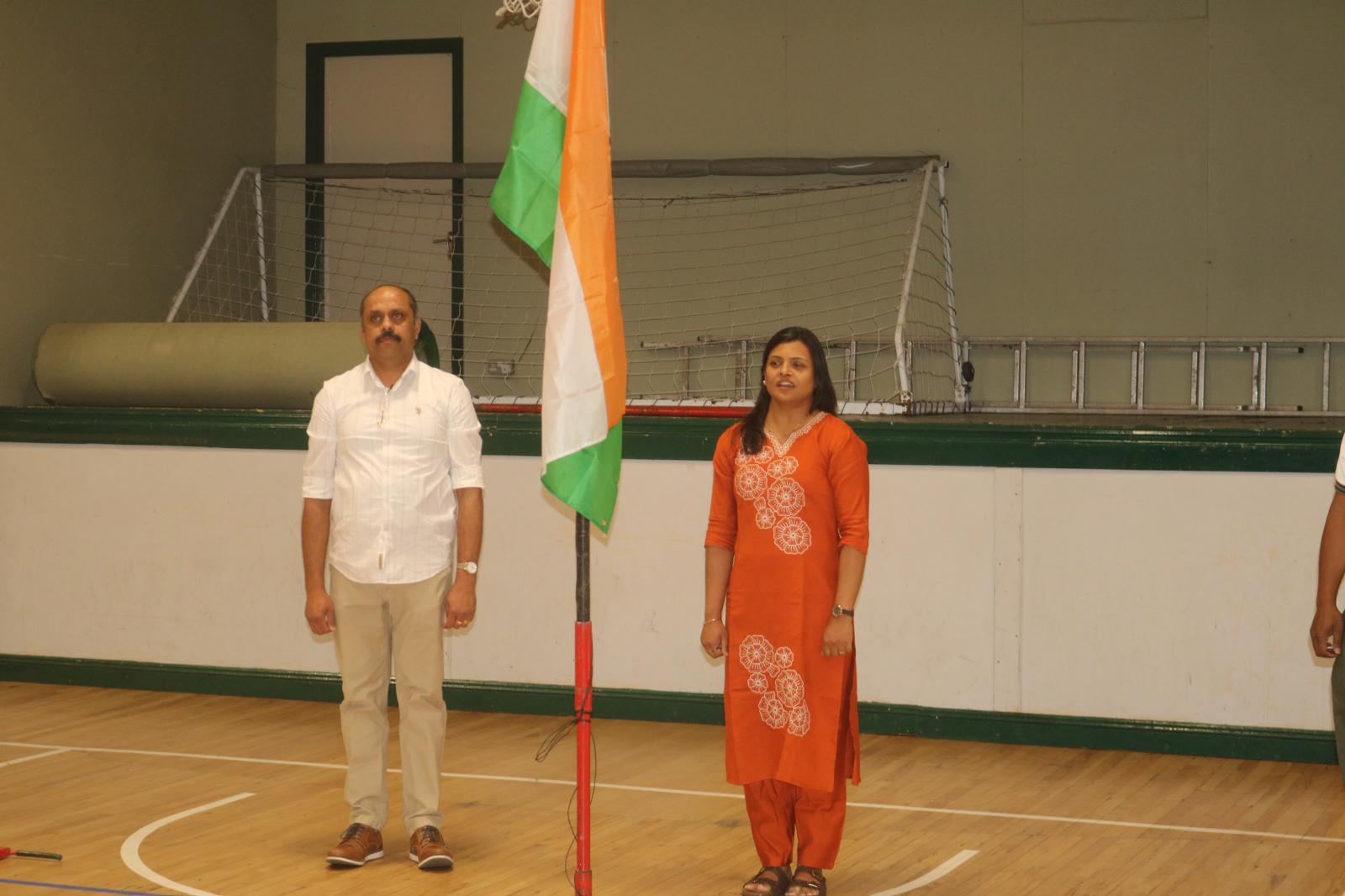 Organisers standing for the national anthem beside the flag